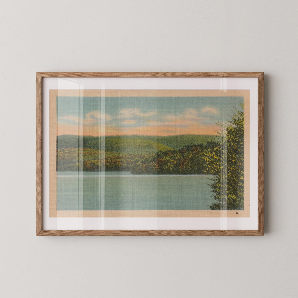 Vintage landscape postcard print of a calm lake framed by trees and distant hills. Printed as a giclée fine art print on archival matte paper.