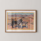 Vintage postcard print of wild donkeys standing in a sun-baked desert landscape dotted with cactus and scrubby brush. Printed as a giclée fine art print on archival matte paper.