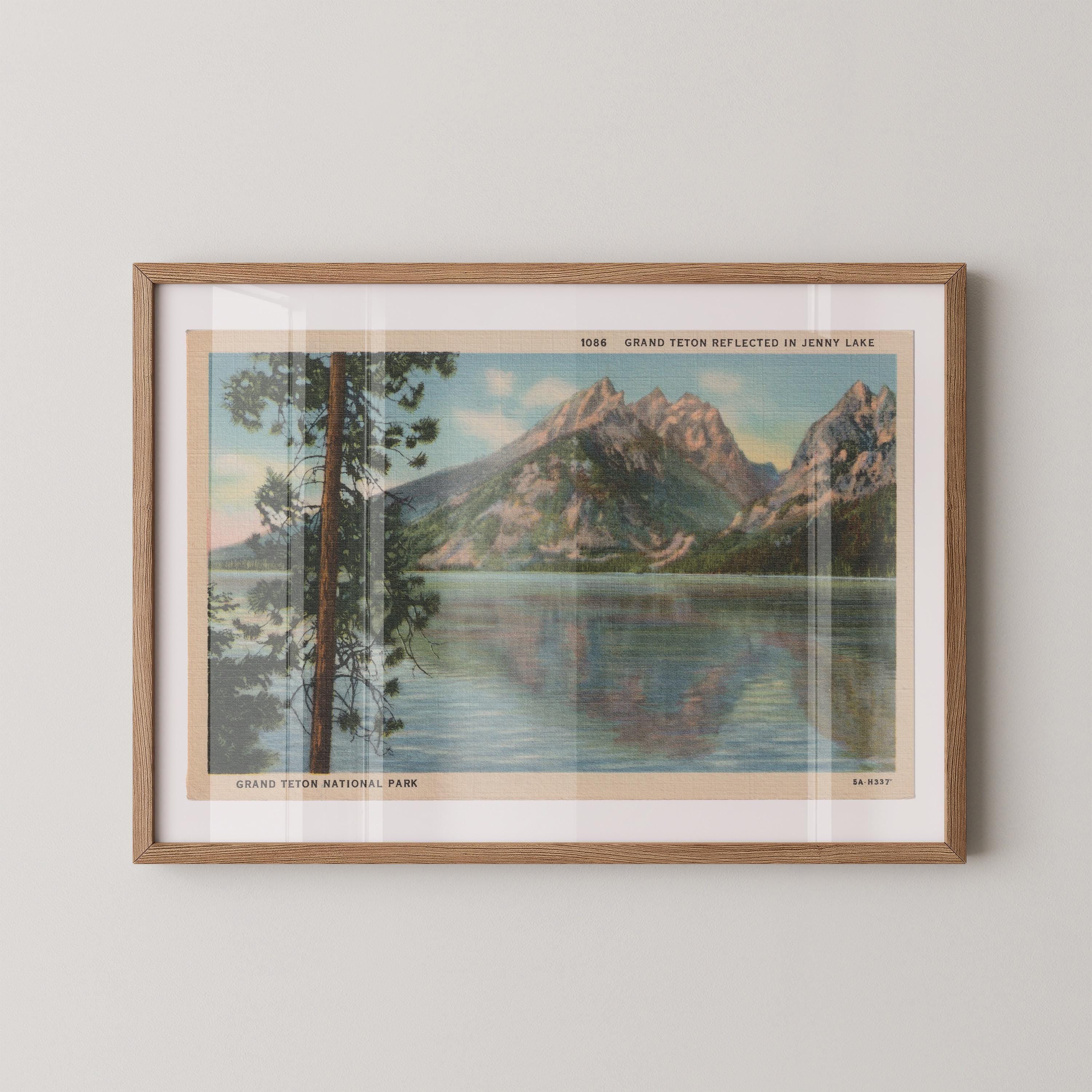 Vintage landscape postcard print of Jenny Lake with the jagged snow-capped peaks of the Grand Tetons reflected in the still water, Grand Teton National Park. Printed as a giclée fine art print on archival matte paper.
